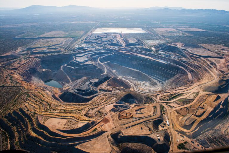 The San Xavier del Bac Mission in the San Xavier District of the Tohono O’odham Reservation, with mines in the distance.