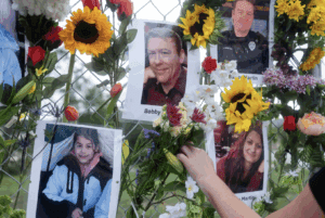Community members add flowers to a memorial on July 9 honoring victims of the flood in Kerrville