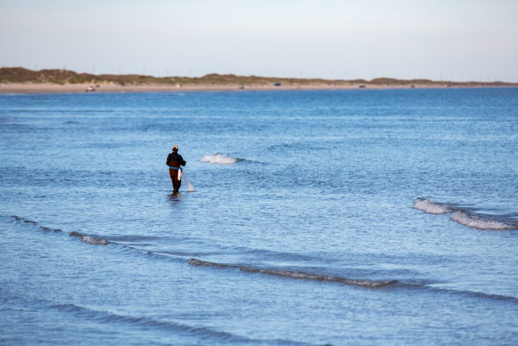 Image of a fisherman surrounded by the waves of the sea.